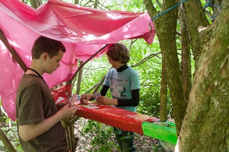 Zwei Jungs spielen Karten in ihrem selbstgebauten Versteck